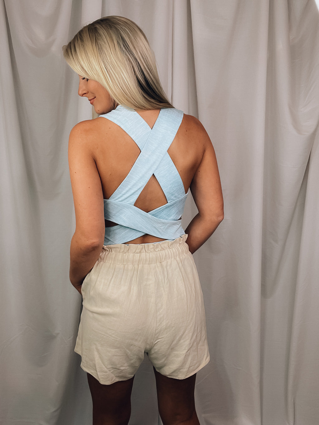 Bodysuit features a heathered light blue color, square neck line, sleeveless detail, cross-open back detail, snap bottom closure, fitted fit and runs true to size! 