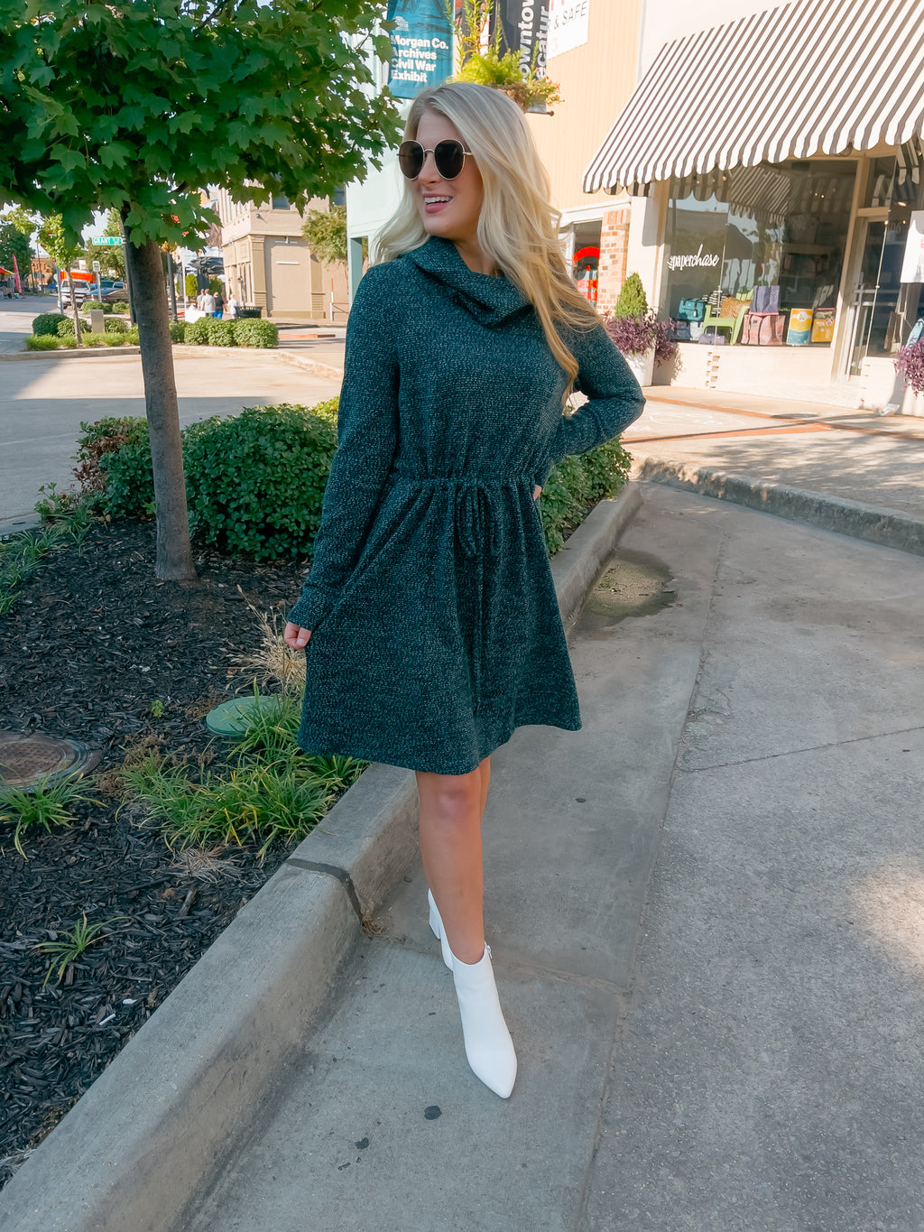 Dress features a deep hunter green color, soft sweater material, long sleeves, elastic tie drawstring, cowl neck line and runs true to size! 