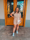 Romper features a neutral taupe color, short sleeves, waist strap detail, button black closure and runs true to size! 
