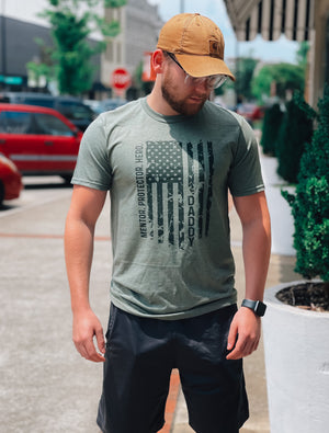 Give the strongest man in your life the perfect Father's Day gift with this Graphic Tee! Featuring bold words that aptly describe him (hero, mentor, protector, Daddy!), this tee is sure to bring a smile to his face. Perfect for days out and special occasions alike!     2XL will be printed on an ash grey instead of a military green 🖤