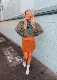 Woman in floral blouse and brown skirt 