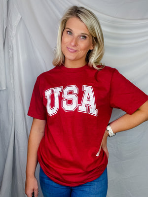 This fun USA Vintage Graphic Tee is sure to make a statement! Whether you're just showing a bit of patriot pride or you're ready to 'Murica it up, it's the perfect choice. With classic USA jersey lettering, short sleeves, and a unisex fit, you'll be stylish and comfy all day long!-red