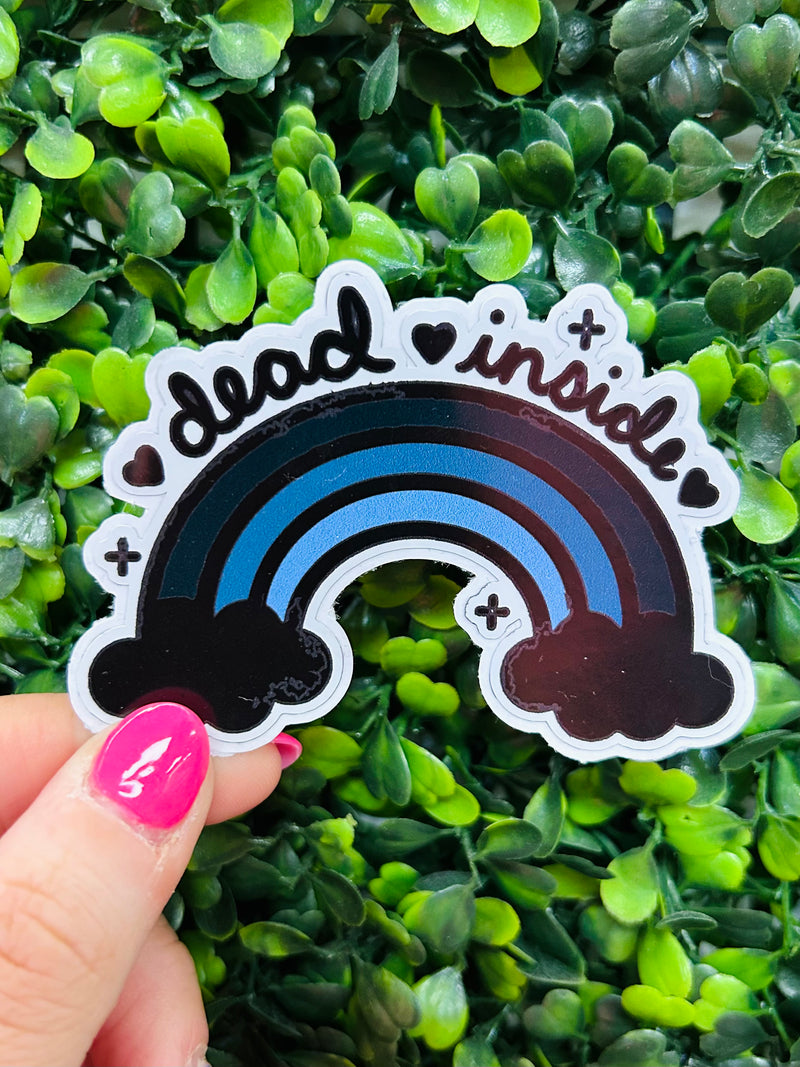 Slap a Dead Inside Sticker on your laptop or backpack and add some fun to your day. With a black rainbow and humorous message, it'll help you express yourself in the quirkiest of ways. Gonna keep up your spooky vibe? This sticker is the perfect choice!