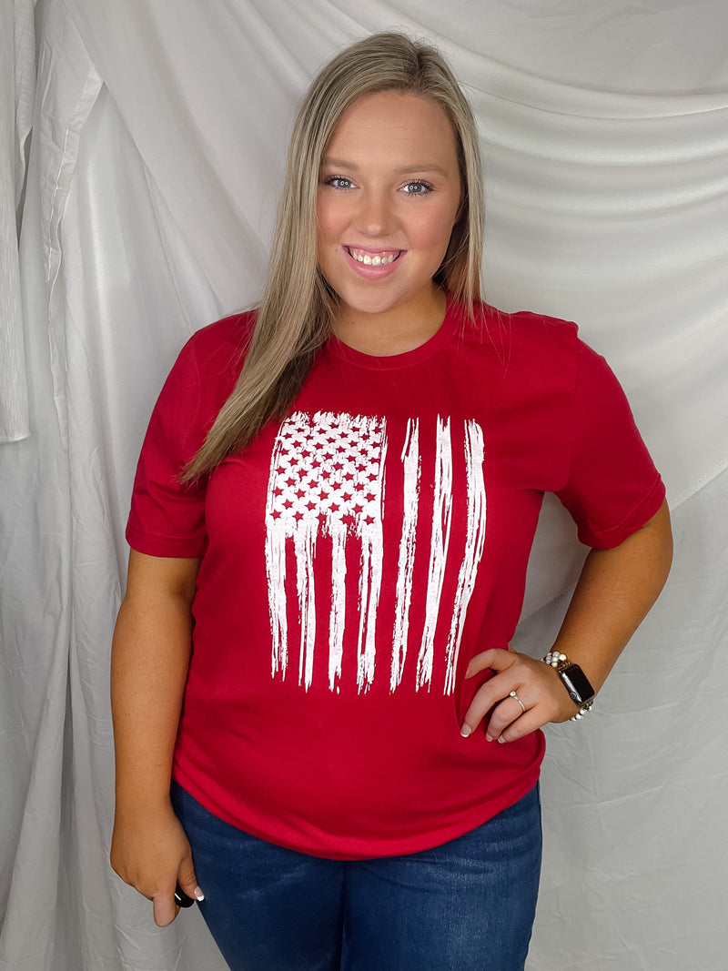 This patriotic tee will make any heart swell with pride! It features a distressed flag design with a bold, unisex fit and a classic round neckline. Honor your country in style with this must-have tee!-red