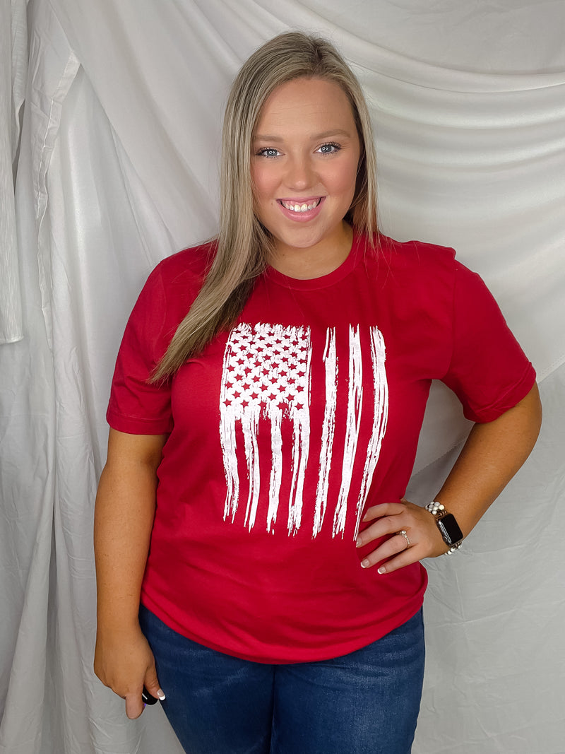 This patriotic tee will make any heart swell with pride! It features a distressed flag design with a bold, unisex fit and a classic round neckline. Honor your country in style with this must-have tee!-red