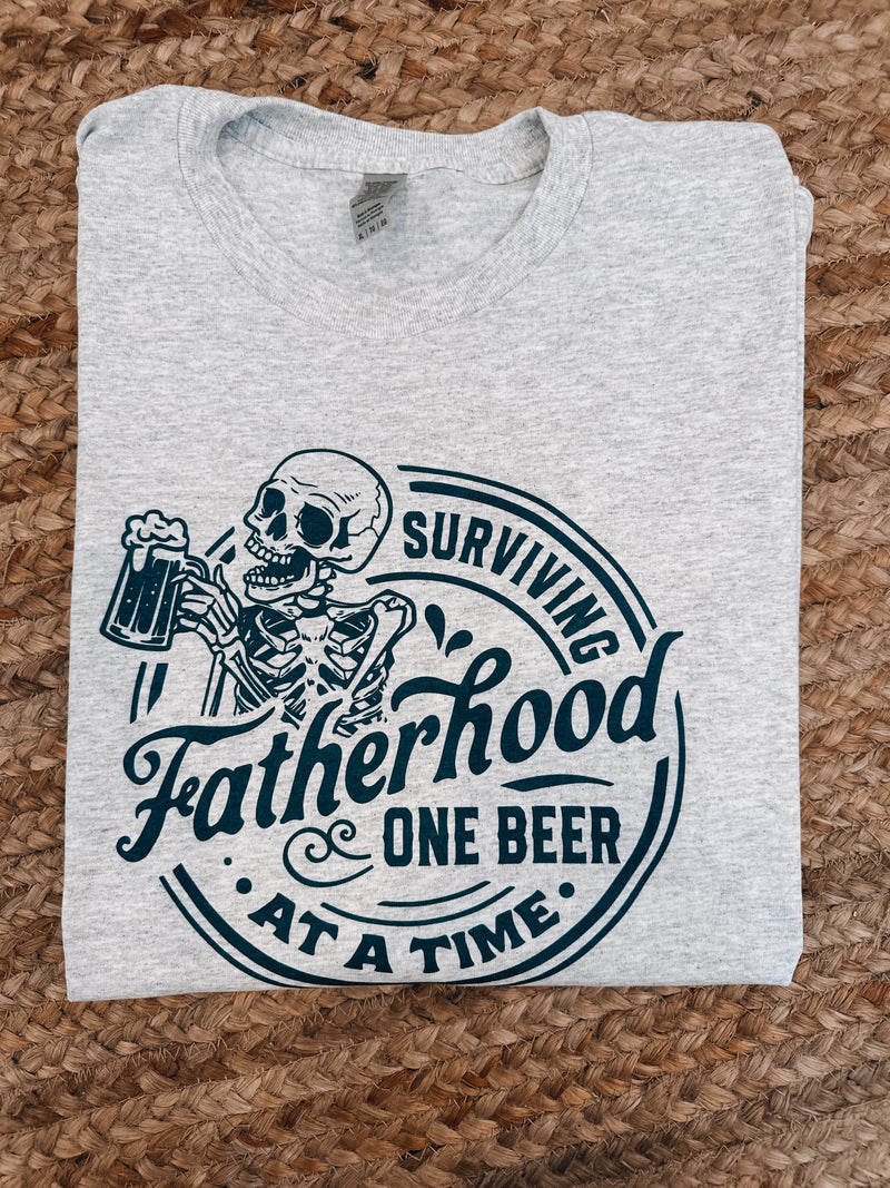 For all the Dad jokes and diaper changes, show your appreciation with the perfect Father's Day gift! Get a laugh and a smile with this Surviving Fatherhood One Beer At A Time Graphic Tee. Its unisex fit and short sleeves make it a comfortable, light-hearted way to thank Dad this Father's Day! Cheers to Dad!