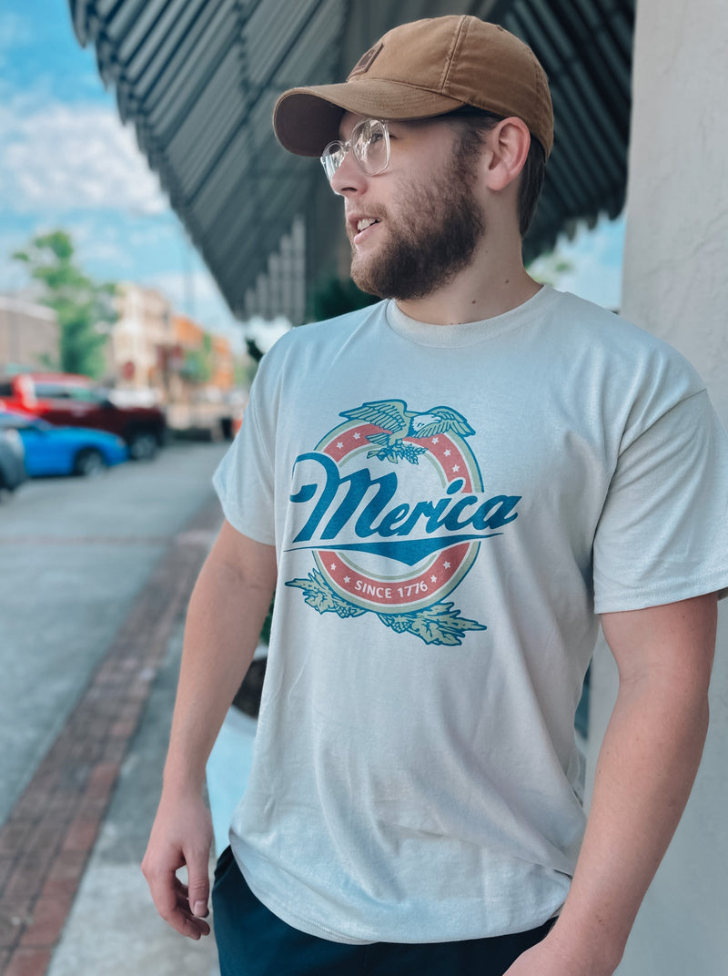 Show your American pride in this Merica Since 1776 graphic tee! Perfect for BBQs, 4th of July, or simply getting together with friends, you'll be the star-spangled sensation in this patriotic fit. Who said fashion and patriotism don't mix?  2XL will be printed on an ash grey instead of a tan color🖤