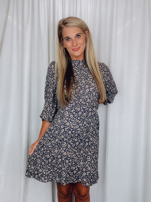 Dress features a charcoal base, taupe print detail, long sleeves, ruffle neck line and runs true to size 