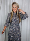 Dress features a charcoal base, taupe print detail, long sleeves, ruffle neck line and runs true to size 