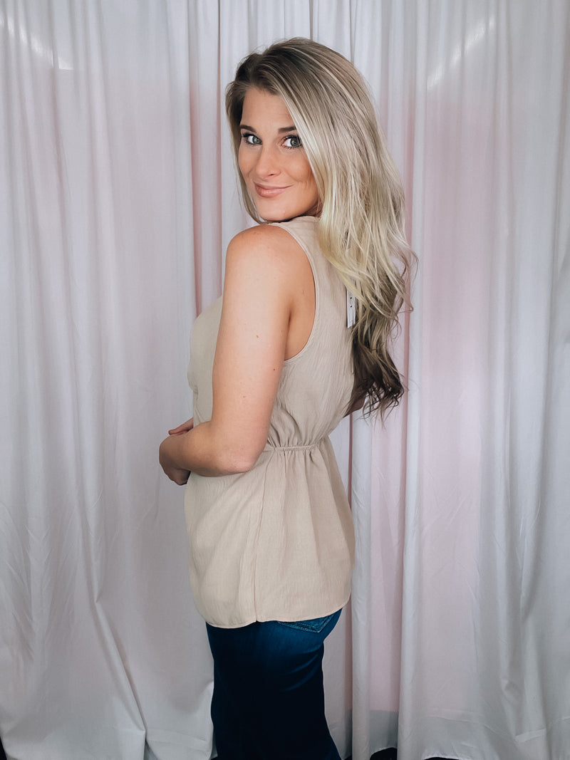 This versatile top is a perfect statement piece for all seasons. Crafted with an elegant taupe color, the Subtly Sweet Top features a sleeveless design, a round neckline, layered detailing and a front twist knot detail. Its neutral color complements any outfit and is sure to add a stylish touch to your wardrobe.  Top features a neutral beige color, sleeveless detail, round neck line, twist knot detail, layered look and runs true to size! 