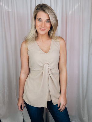 This versatile top is a perfect statement piece for all seasons. Crafted with an elegant taupe color, the Subtly Sweet Top features a sleeveless design, a round neckline, layered detailing and a front twist knot detail. Its neutral color complements any outfit and is sure to add a stylish touch to your wardrobe.  Top features a neutral beige color, sleeveless detail, round neck line, twist knot detail, layered look and runs true to size! 