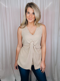 This versatile top is a perfect statement piece for all seasons. Crafted with an elegant taupe color, the Subtly Sweet Top features a sleeveless design, a round neckline, layered detailing and a front twist knot detail. Its neutral color complements any outfit and is sure to add a stylish touch to your wardrobe.  Top features a neutral beige color, sleeveless detail, round neck line, twist knot detail, layered look and runs true to size! 