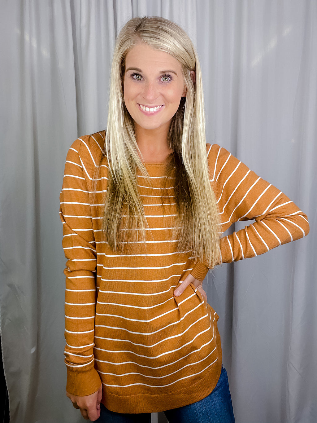 Top features a solid base color, ivory striped detailing, boat neck line, long sleeves, U-shaped hemline, and runs true to size! -camel
