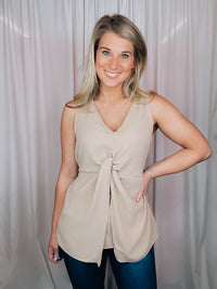 This versatile top is a perfect statement piece for all seasons. Crafted with an elegant taupe color, the Subtly Sweet Top features a sleeveless design, a round neckline, layered detailing and a front twist knot detail. Its neutral color complements any outfit and is sure to add a stylish touch to your wardrobe.  Top features a neutral beige color, sleeveless detail, round neck line, twist knot detail, layered look and runs true to size! 