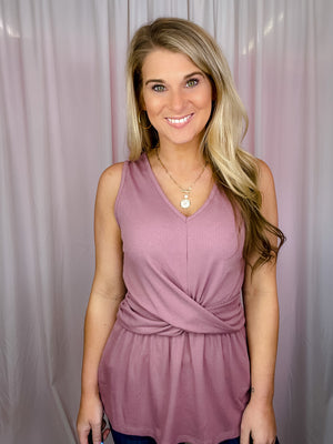 This top is crafted from ribbed mauve fabric, featuring an eye-catching front twist knot and a flattering V-neck. With its sleeveless design, you can enjoy the perfect style balance between comfort and fashion.