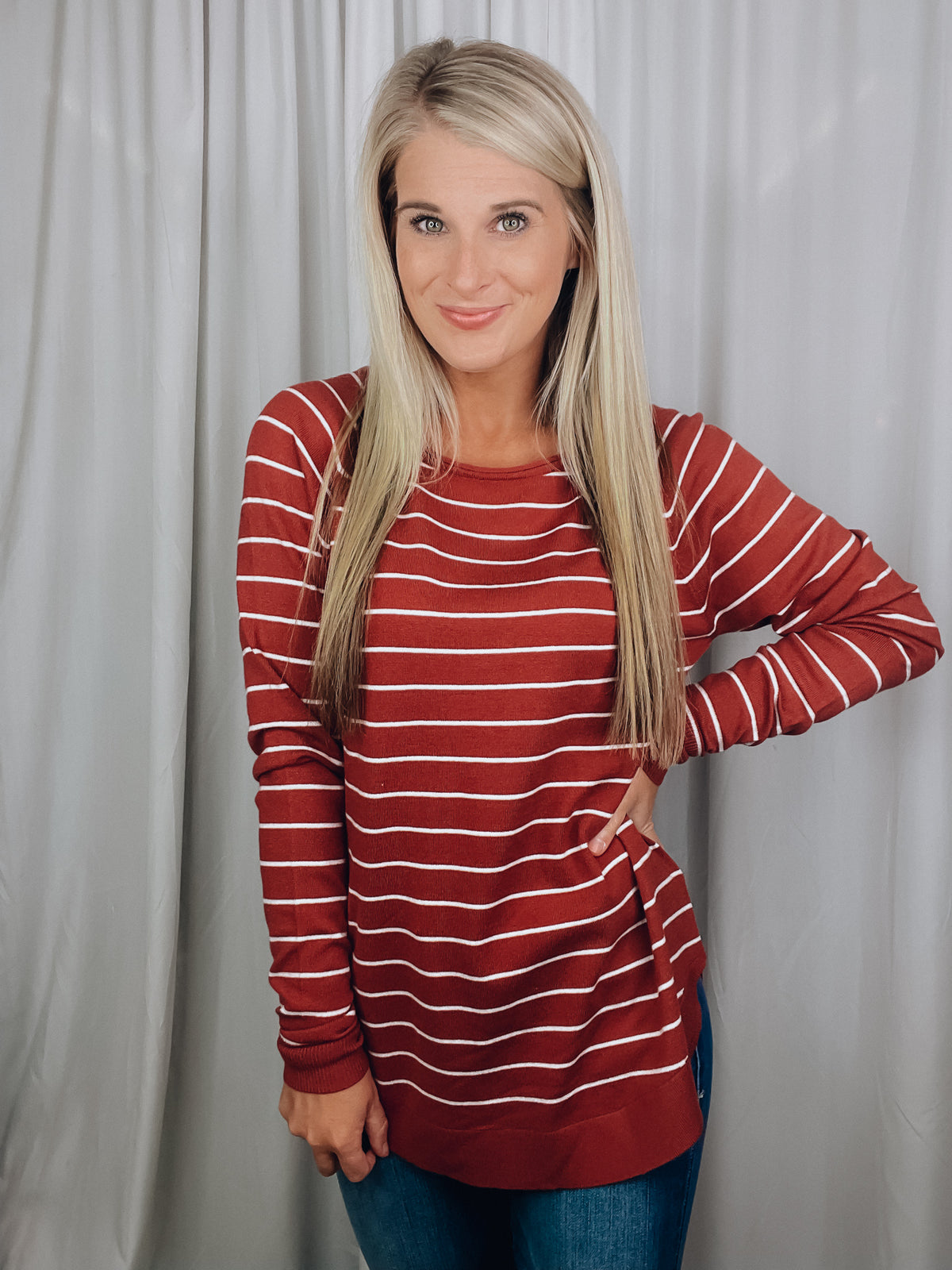 Top features a solid base color, ivory striped detailing, boat neck line, long sleeves, U-shaped hemline, and runs true to size! -rust