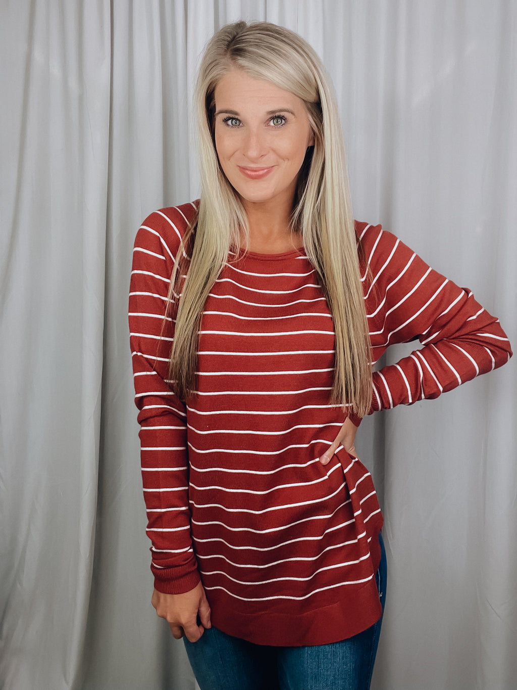 Top features a solid base color, ivory striped detailing, boat neck line, long sleeves, U-shaped hemline, and runs true to size! -rust