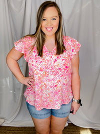 Top features a pink floral print, short ruffle sleeves, V-neck line and runs true to size! 