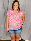 Top features a pink floral print, short ruffle sleeves, V-neck line and runs true to size! 