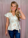 Our Flirty Darling Top showcases a mint base adorned with a beautiful floral print, featuring short sleeves and a V-neck line. The waist is cinched for a flattering fit, and tie detail adds a romantic touch. Make a statement with this elegant and feminine piece.