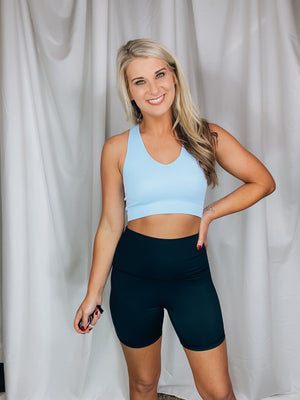 Top features a fitted fit, razor back detail, non padded top, ribbed stretchy material, cropped length and runs true to size! -BLUE