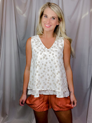 Top features an ivory base, taupe abstract print, V-neck line, sleeveless detail, layered bottom detailing and runs true to size! 