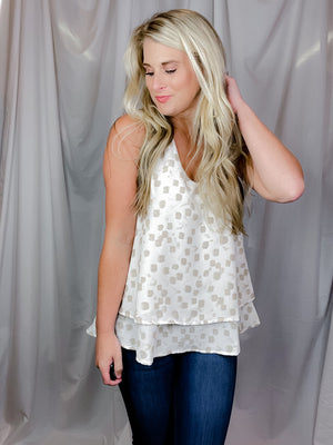 Top features an ivory base, taupe abstract print, V-neck line, sleeveless detail, layered bottom detailing and runs true to size! 