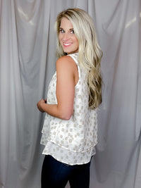 Top features an ivory base, taupe abstract print, V-neck line, sleeveless detail, layered bottom detailing and runs true to size! 