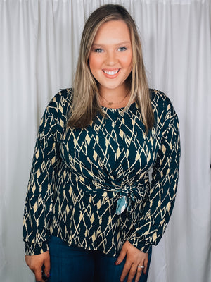 Top features a hunter green base, cream abstract print, long sleeves, V-neck line, tie front detail and runs true to size! 