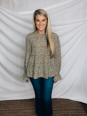 Top features a solid base color, paint stroke design, long sleeves, round neck, light weight material, cinched ruffle sleeves and runs true to size!   100% Polyester -SAGE