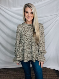 Top features a solid base color, paint stroke design, long sleeves, round neck, light weight material, cinched ruffle sleeves and runs true to size!   100% Polyester -SAGE