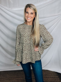 Top features a solid base color, paint stroke design, long sleeves, round neck, light weight material, cinched ruffle sleeves and runs true to size!   100% Polyester -SAGE