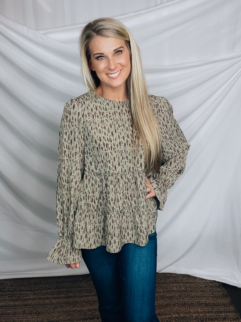 Top features a solid base color, paint stroke design, long sleeves, round neck, light weight material, cinched ruffle sleeves and runs true to size!   100% Polyester -SAGE