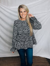 Top features a solid base color, paint stroke design, long sleeves, round neck, light weight material, cinched ruffle sleeves and runs true to size!   100% Polyester -BLACK