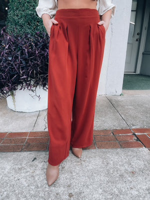 Bottoms feature a flowy polyester material, deep rust color, high waist band, front pleated detailing, functional side pockets, wide leg and runs true to size! 