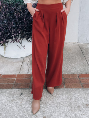 Bottoms feature a flowy polyester material, deep rust color, high waist band, front pleated detailing, functional side pockets, wide leg and runs true to size! 