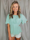 Top features a solid base color, boat neck, short sleeves, ruched front, textured material and runs true to size!-MINT