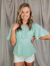 Top features a solid base color, boat neck, short sleeves, ruched front, textured material and runs true to size! -MINT