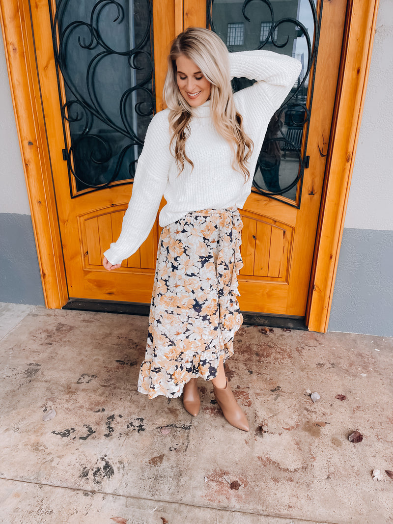 Skirt features a navy base, white & mustard floral print, ruffle skirt bottom, elastic waist band, tie belt detail and runs true to size! 