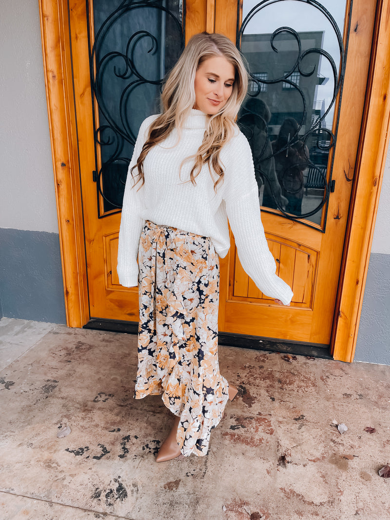 Skirt features a navy base, white & mustard floral print, ruffle skirt bottom, elastic waist band, tie belt detail and runs true to size! 