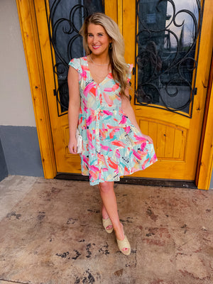 The Deeper Connection Dress features short ruffle sleeves, vibrant coloring, and functional button down detailing, which provide figure-flattering elements. Further enhancing this look, a tiered skirt and V-neck line combine to provide an eye-catching and stylish look.