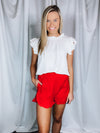 Bottoms feature a solid base color, elastic waistband, ruffle detailing around the pockets and bottom of the shorts, functional pockets, under lining and runs true to size!-tomato