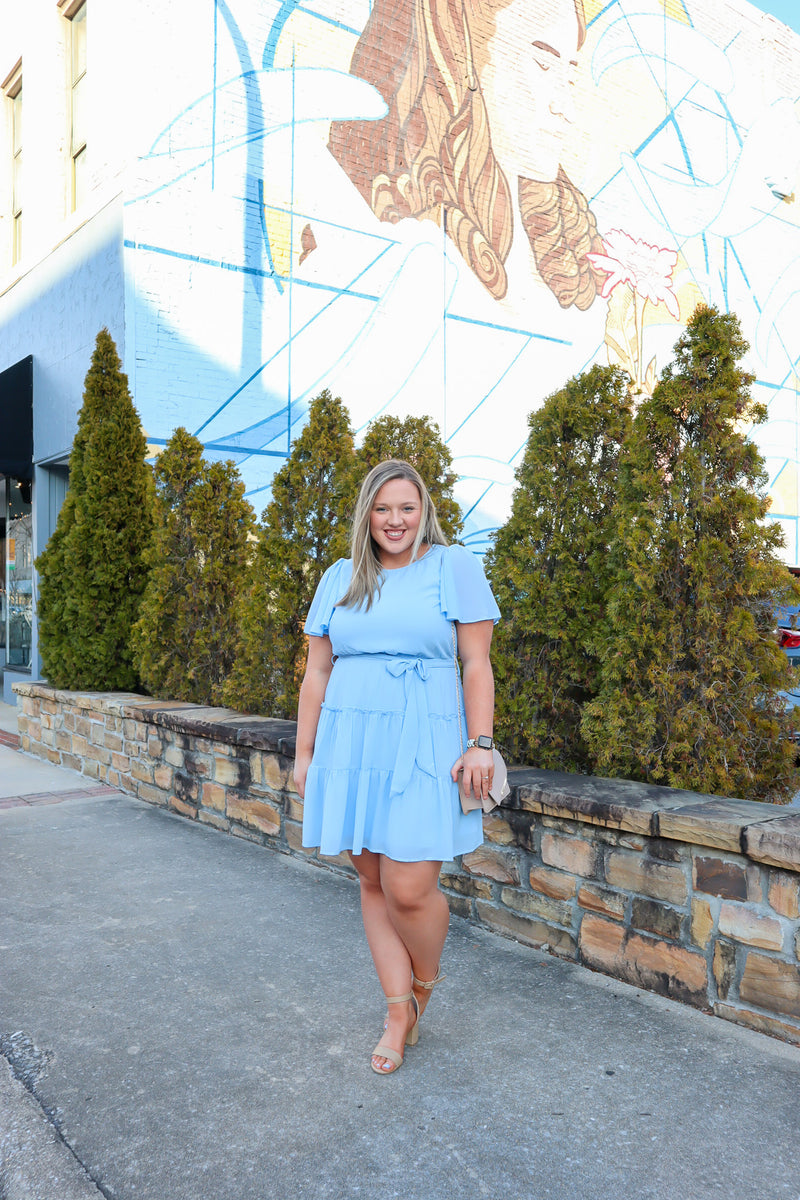 Dress features a stunning powder blue color, solid butterfly sleeve, ruffle tiered skirt, side pockets, round neck line, and runs true to size! 