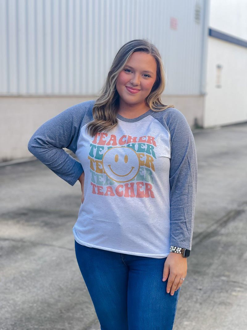 Welcome to school in (style)! Show your teacher pride with this adorably quirky Teacher Smile Face Raglan. The 3/4 sleeves and fun design will keep you looking your best while feeling totally carefree. Let your inner teacher shine with this unique look — you'll be fetching 'A's all year long! (No detention required.)  Printed on our unisex loose fitting raglans