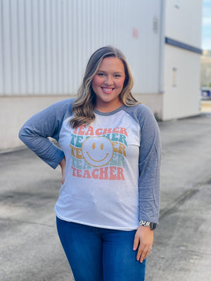 Welcome to school in (style)! Show your teacher pride with this adorably quirky Teacher Smile Face Raglan. The 3/4 sleeves and fun design will keep you looking your best while feeling totally carefree. Let your inner teacher shine with this unique look — you'll be fetching 'A's all year long! (No detention required.)  Printed on our unisex loose fitting raglans