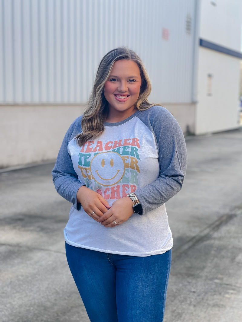 Welcome to school in (style)! Show your teacher pride with this adorably quirky Teacher Smile Face Raglan. The 3/4 sleeves and fun design will keep you looking your best while feeling totally carefree. Let your inner teacher shine with this unique look — you'll be fetching 'A's all year long! (No detention required.)  Printed on our unisex loose fitting raglans