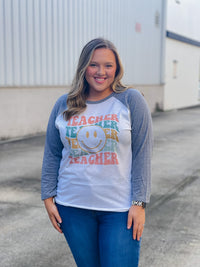 Welcome to school in (style)! Show your teacher pride with this adorably quirky Teacher Smile Face Raglan. The 3/4 sleeves and fun design will keep you looking your best while feeling totally carefree. Let your inner teacher shine with this unique look — you'll be fetching 'A's all year long! (No detention required.)  Printed on our unisex loose fitting raglans