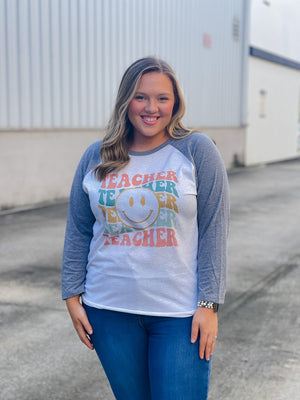 Welcome to school in (style)! Show your teacher pride with this adorably quirky Teacher Smile Face Raglan. The 3/4 sleeves and fun design will keep you looking your best while feeling totally carefree. Let your inner teacher shine with this unique look — you'll be fetching 'A's all year long! (No detention required.)  Printed on our unisex loose fitting raglans
