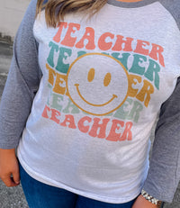 Welcome to school in (style)! Show your teacher pride with this adorably quirky Teacher Smile Face Raglan. The 3/4 sleeves and fun design will keep you looking your best while feeling totally carefree. Let your inner teacher shine with this unique look — you'll be fetching 'A's all year long! (No detention required.)  Printed on our unisex loose fitting raglans