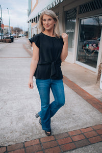 Top features a solid base color, front tie detail, short flutter sleeves, round neck line, elastic waist, and runs true to size! -black